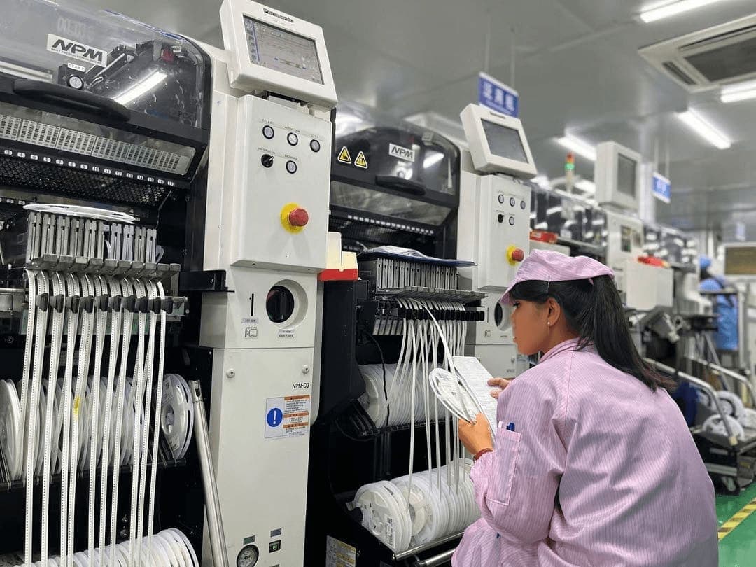 Quality control inspector examining surface-mount (SMD) components on an assembly line
