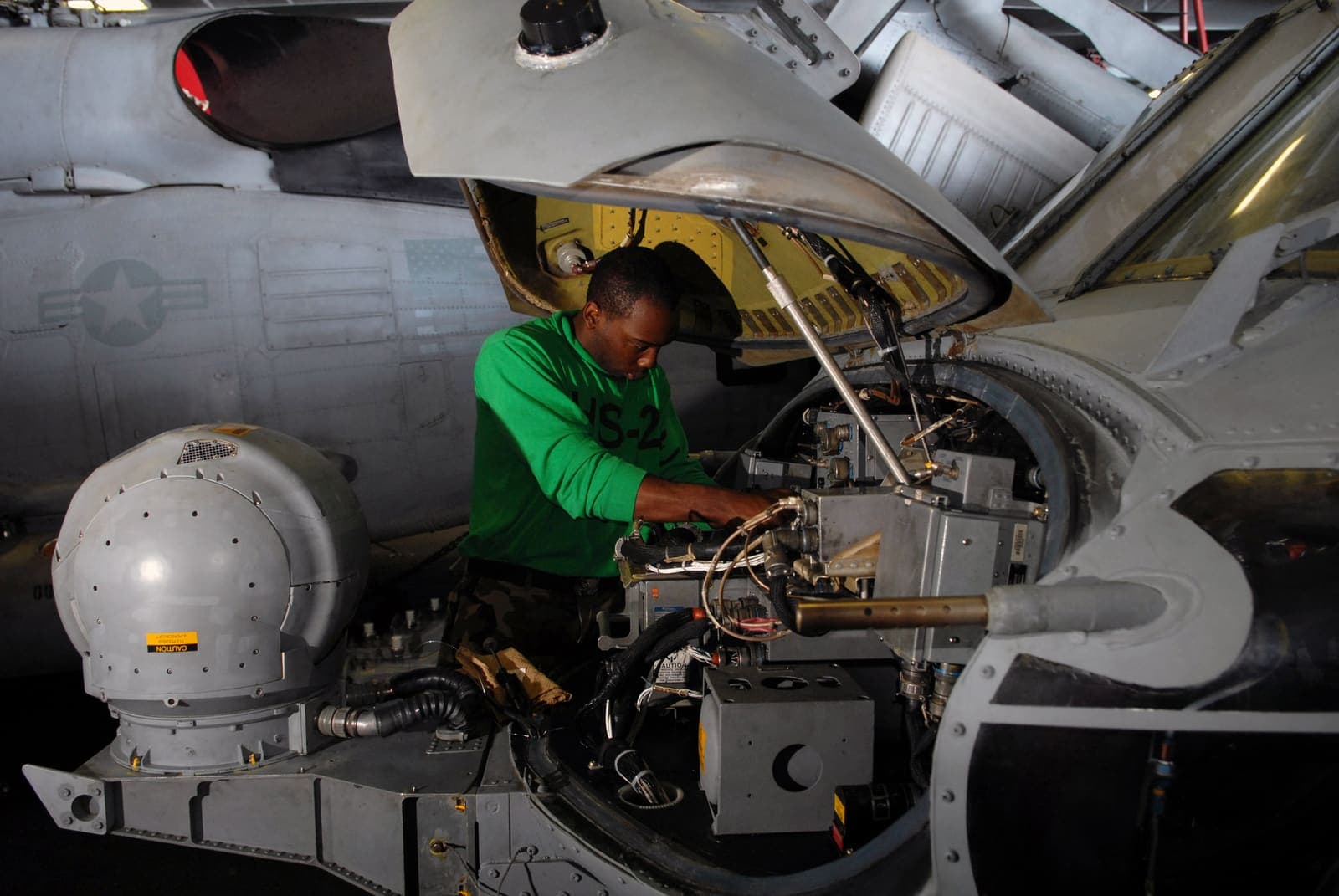 Technician servicing onboard avionics equipment in a military aircraft